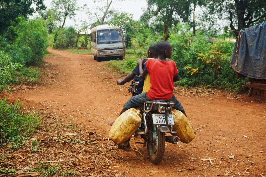 Deux garçons qui font de la moto tout-terrain sur un chemin de terre.
