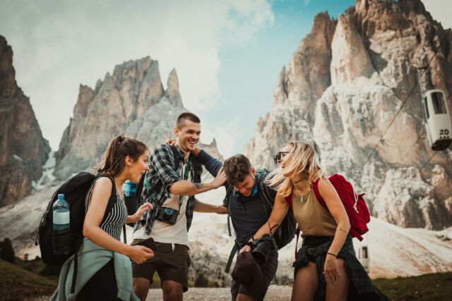 Quatre jeunes adultes riant ensemble lors d'une randonnée en montagne.