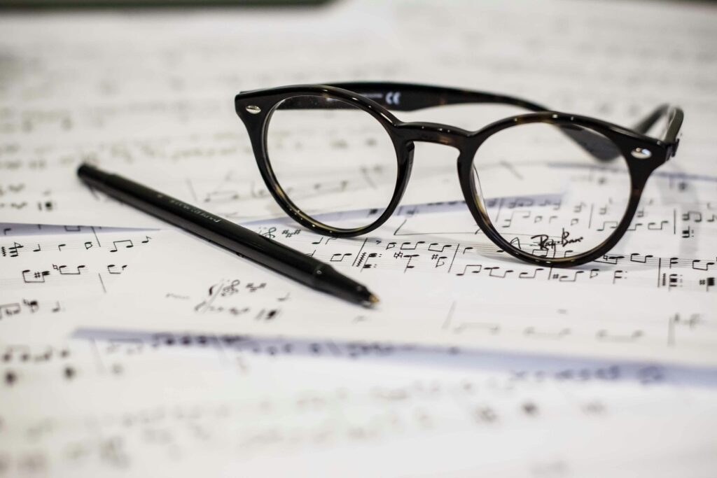 Des lunettes et un stylo sur des partitions.
