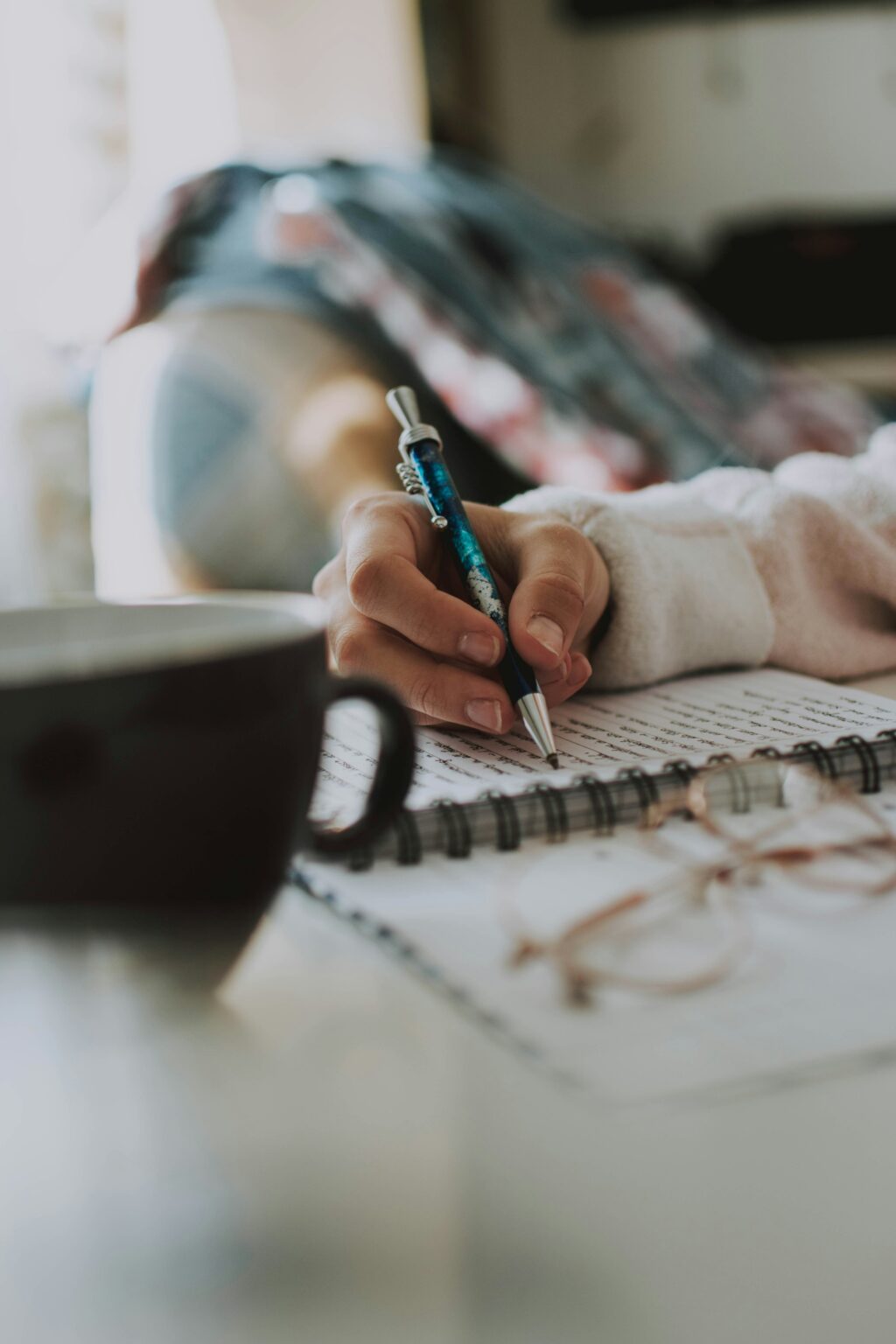 Une femme qui écrit avec un stylo et du papier.