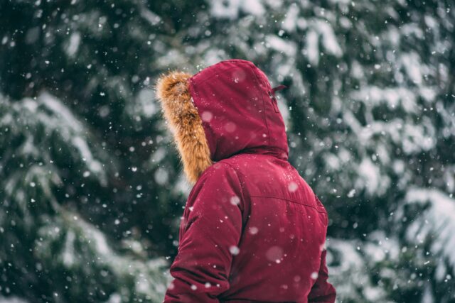 Une personne debout dehors sous la neige.