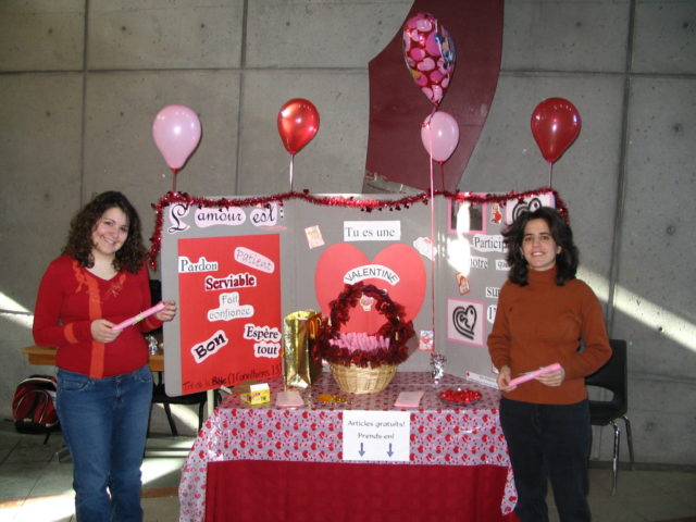 Miryam debout avec une amie à un kiosque de la Saint-Valentin.