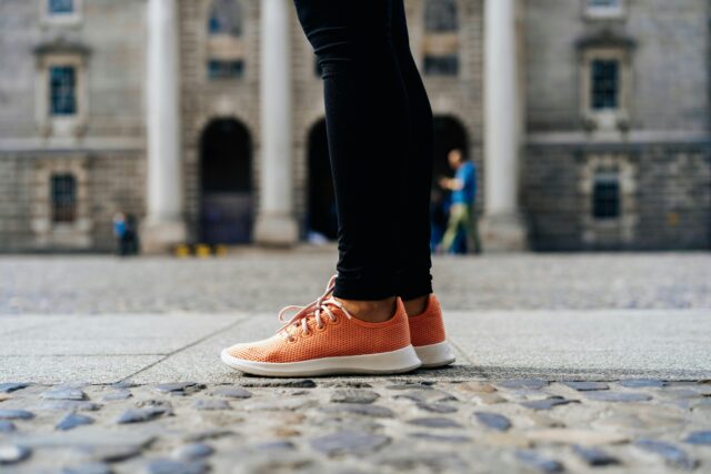 Une personne portant des chaussures orange.