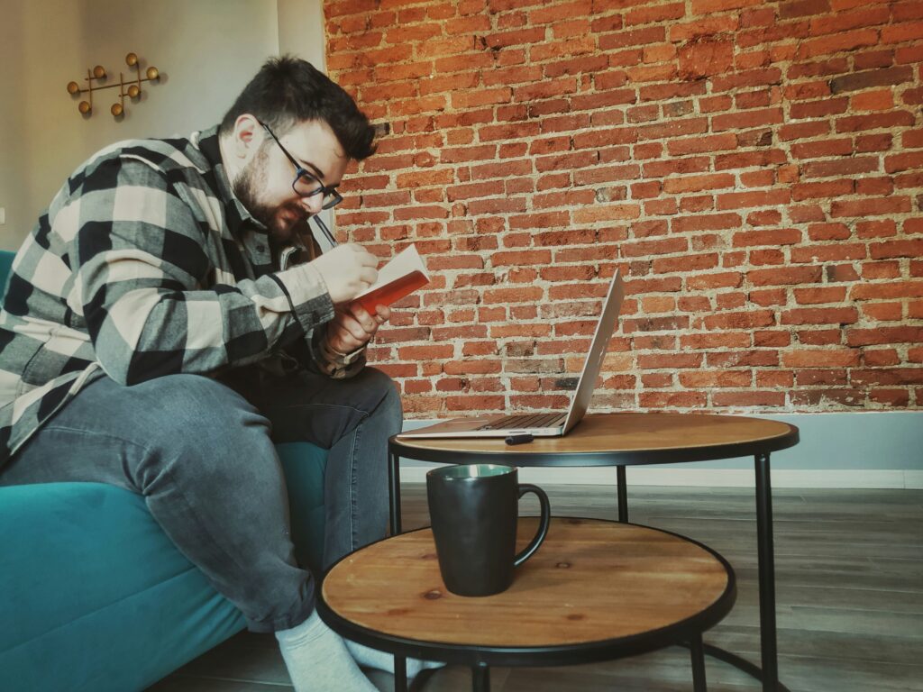 Un homme cherchant des emplois sur son ordinateur portable dans son salon.