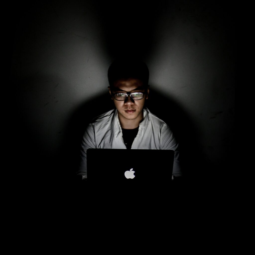 Un jeune homme travaillant sur l'ordinateur la nuit.