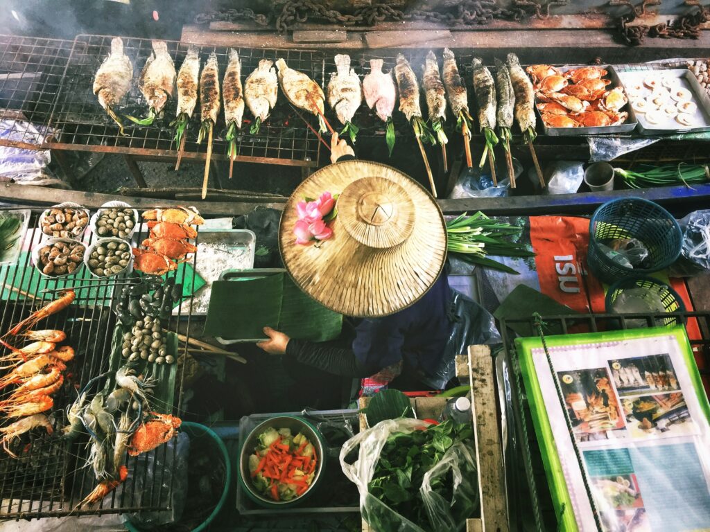Une femme en Asie du Sud entourée de différents types de nourriture.