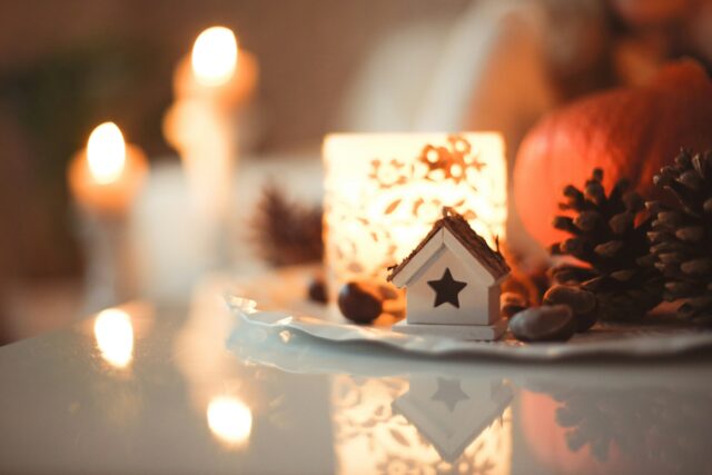 Une petite maison de Noël blanche avec des lumières.