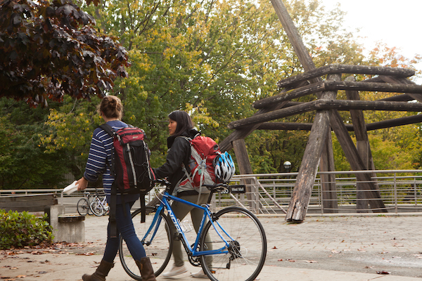 two girls walking bikes
