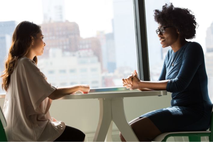 Deux femmes assises à table.