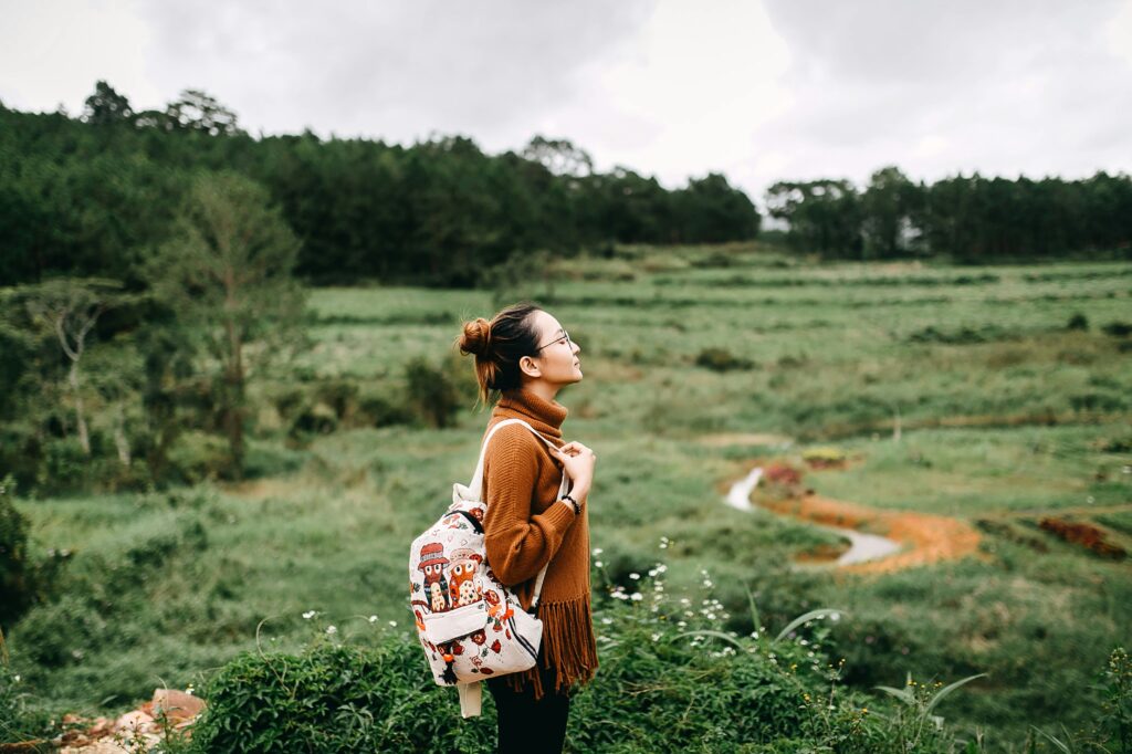 Une jeune femme immobile dans une prairie.