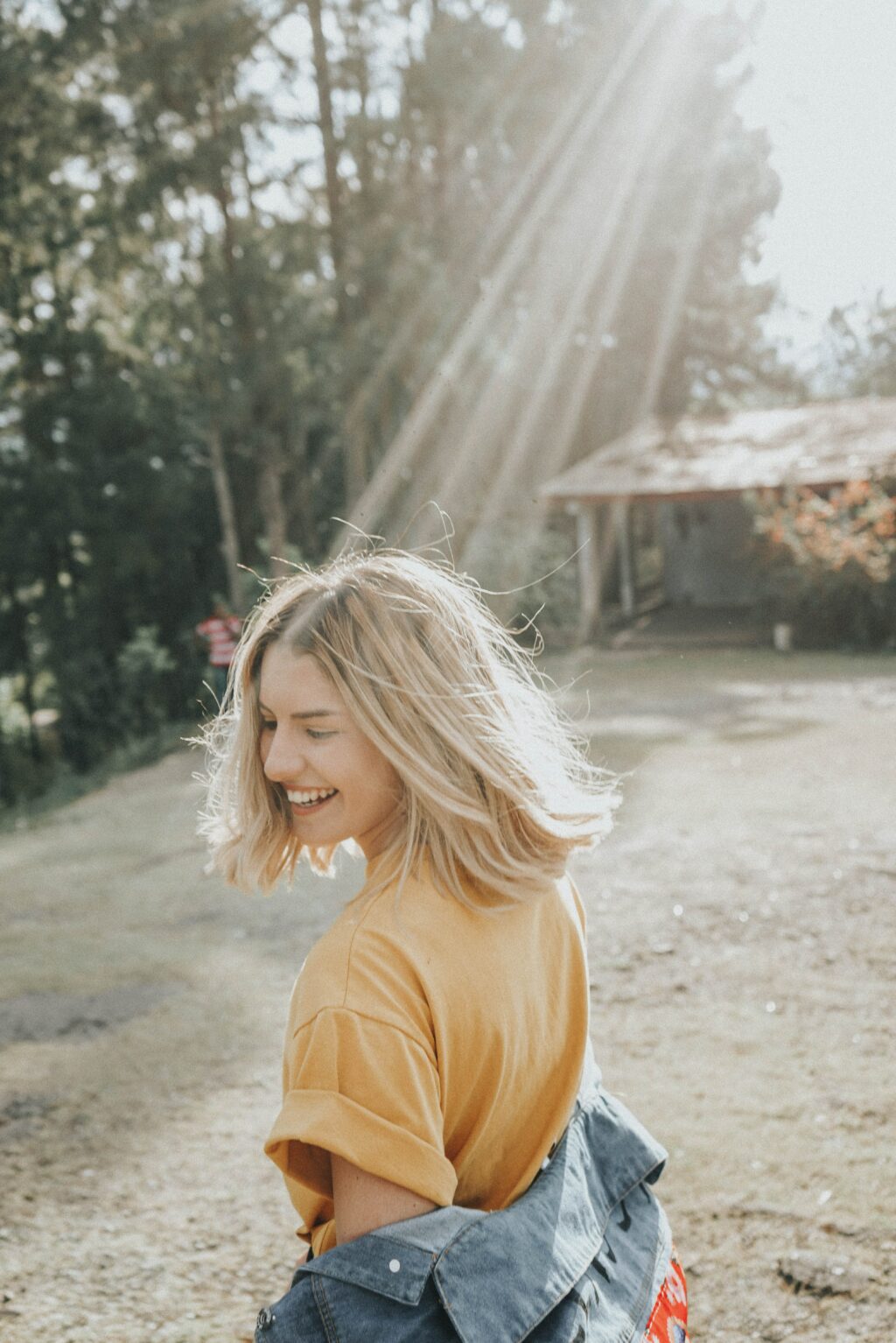 Une jeune femme souriant au soleil.