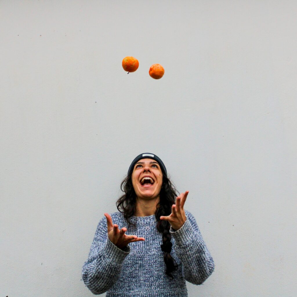 Une femme jonglant avec des fruits.