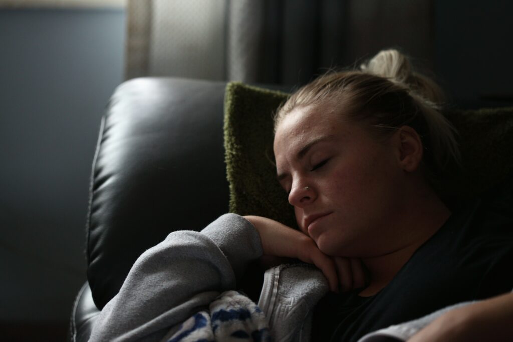 Une femme endormie sur un sofa.