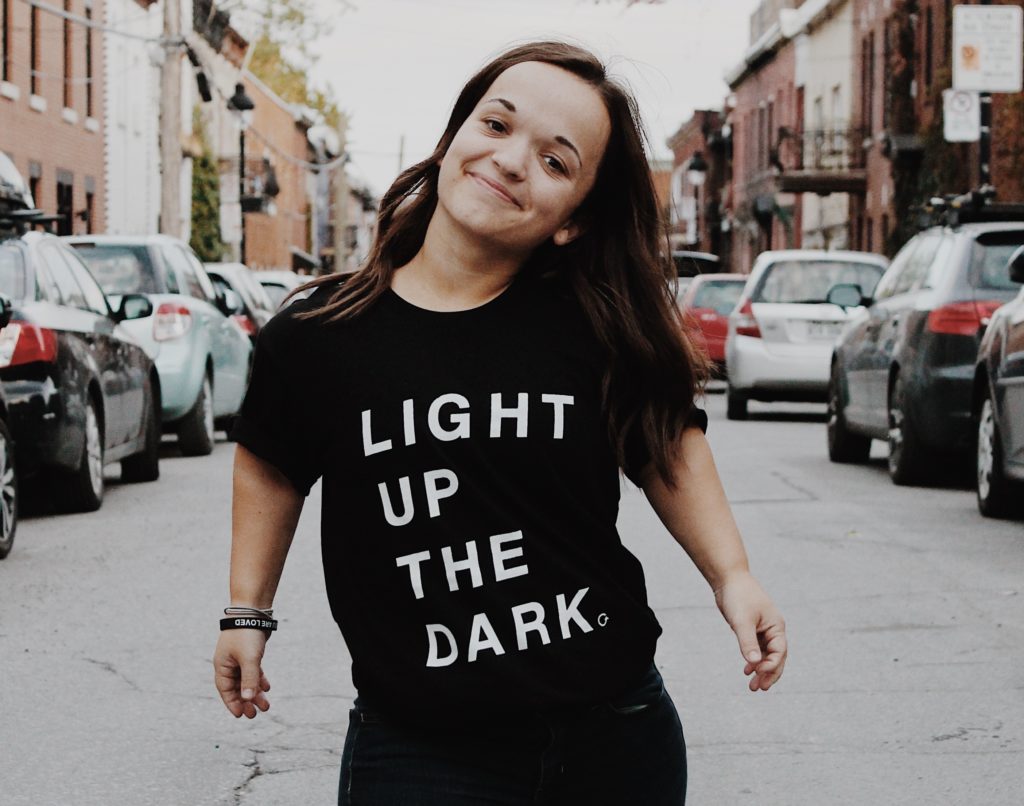 Une femme souriante debout dans la rue.